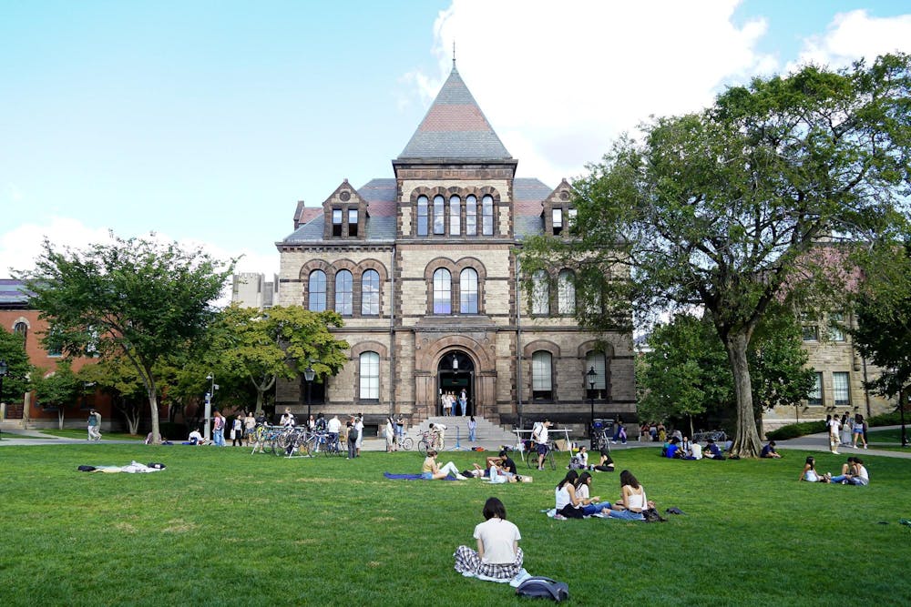 Photo of Sayles Hall with students relaxing on the Main Green.