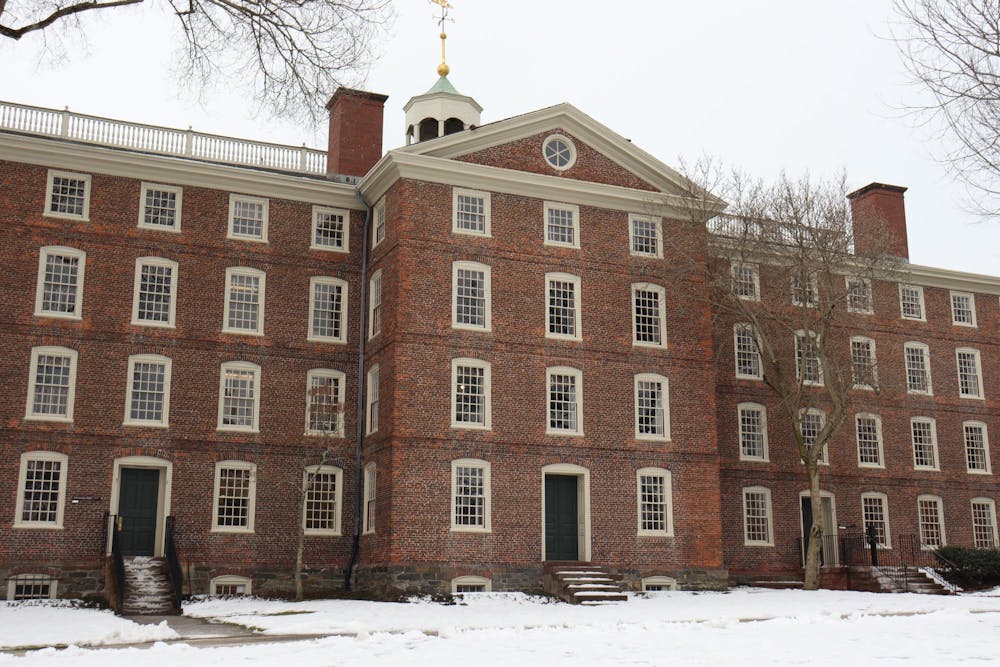 University Hall in the winter with multiple bare trees and snow in the front. 