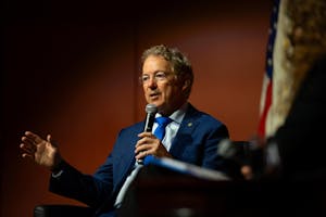 U.S. Sen. Rand Paul, a gray-haired man with glasses and a navy blue suit, solemnly speaks into a microphone onstage.