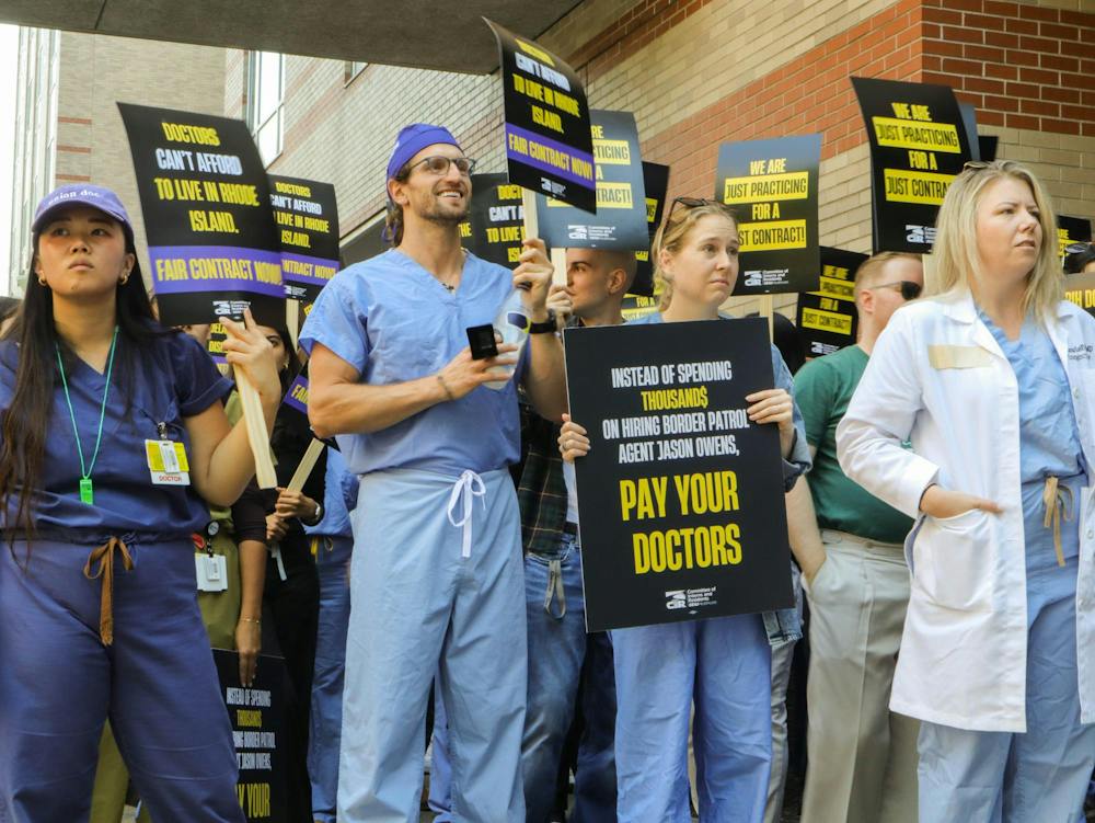 A photo of hospital members in scrubs picketing with signs. 

