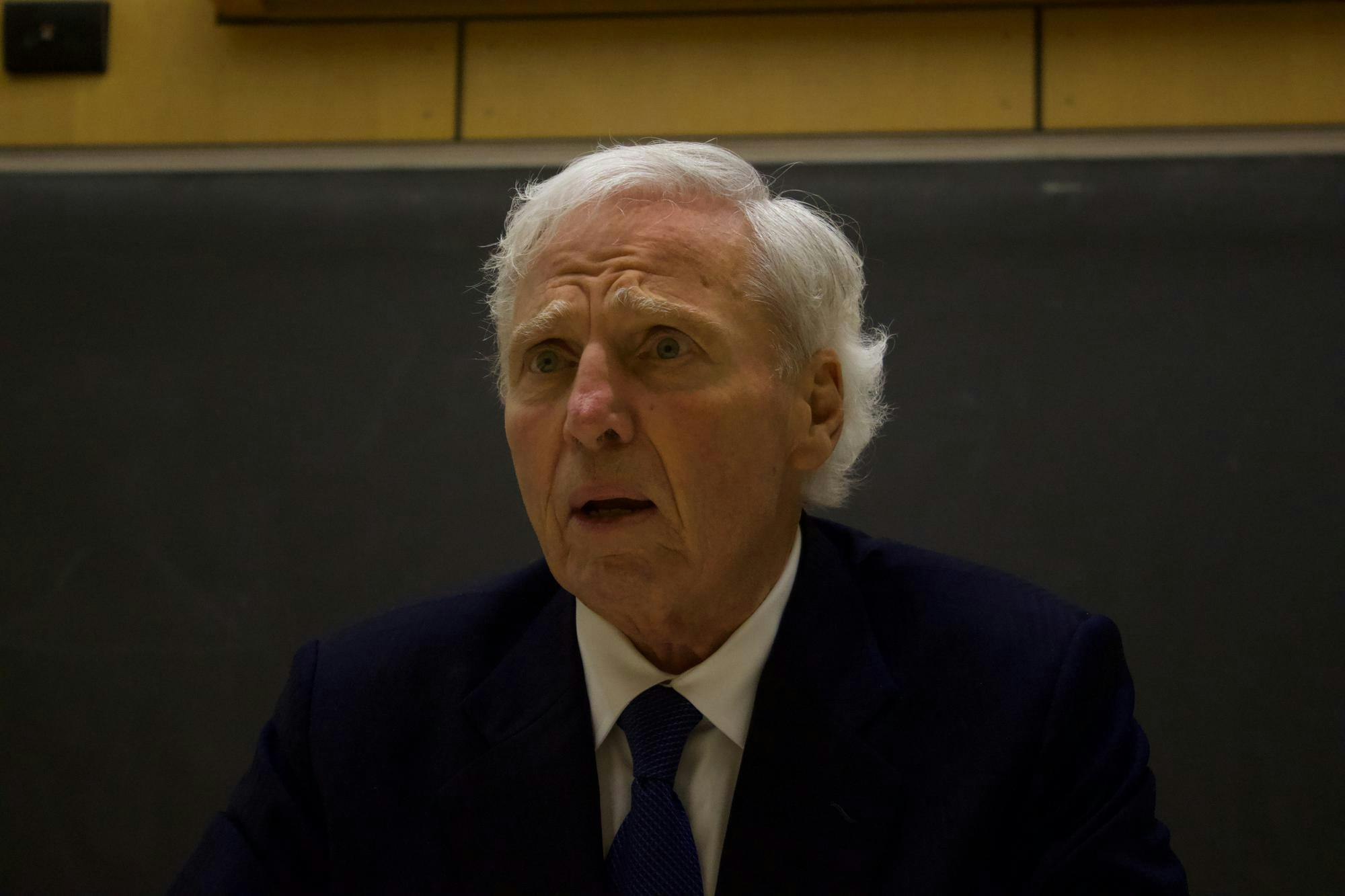 Up-close portrait shot of Andrew von Eschenbach wearing a dark blue suit and a tie with a concerned expression on his face.
