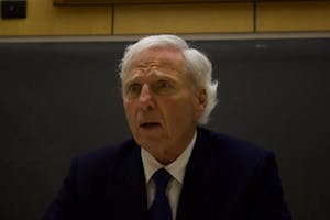 Up-close portrait shot of Andrew von Eschenbach wearing a dark blue suit and a tie with a concerned expression on his face.