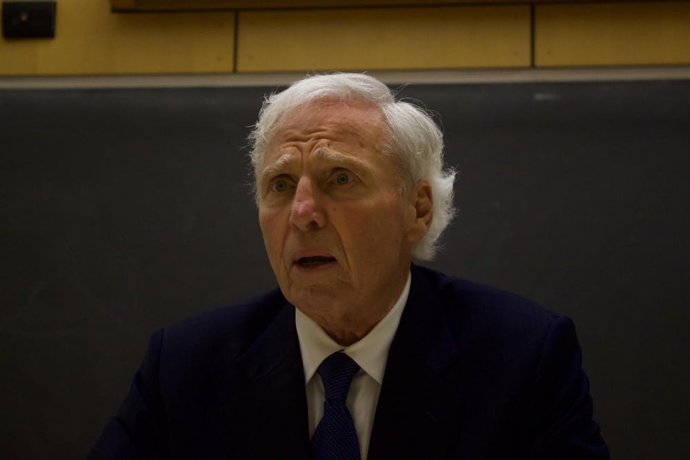 Up-close portrait shot of Andrew von Eschenbach wearing a dark blue suit and a tie with a concerned expression on his face.