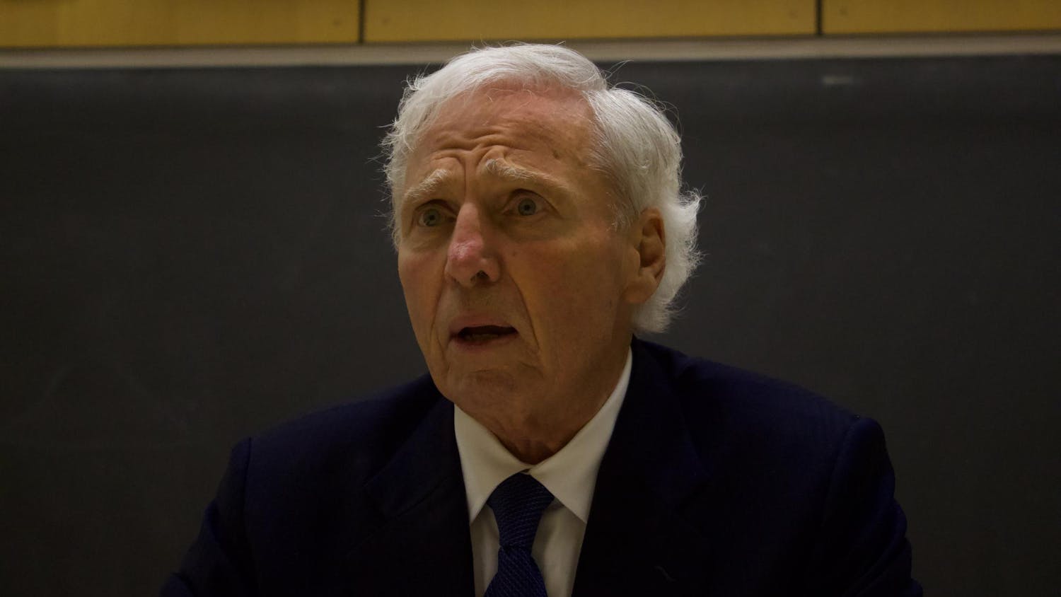 Up-close portrait shot of Andrew von Eschenbach wearing a dark blue suit and a tie with a concerned expression on his face.