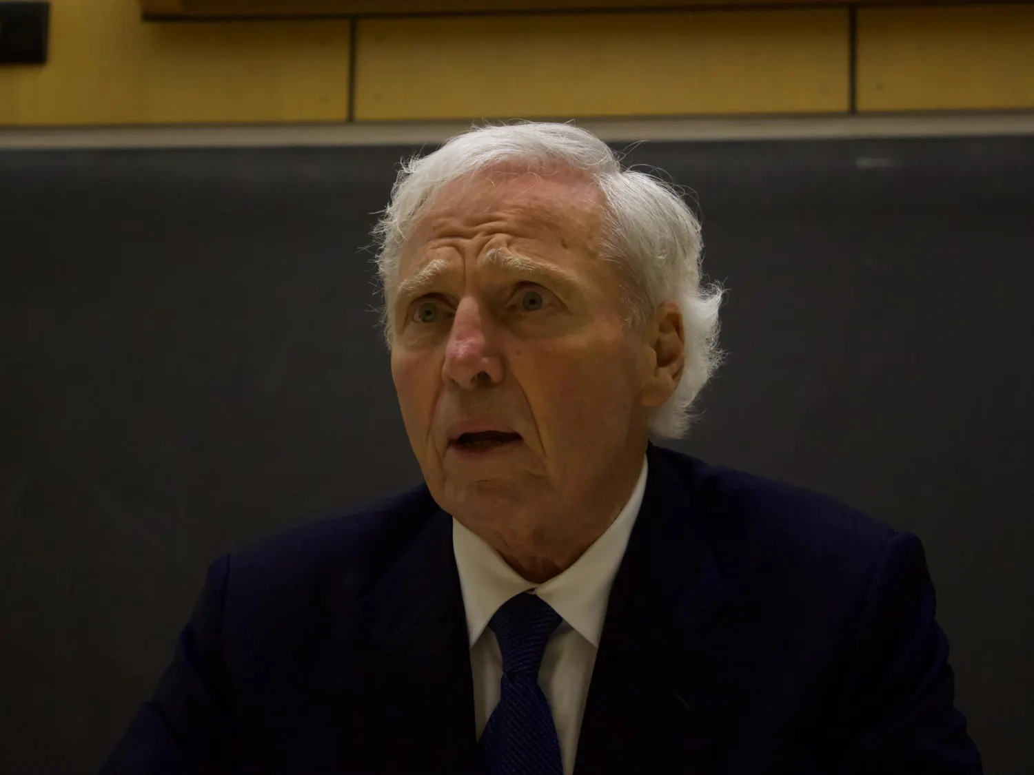 Up-close portrait shot of Andrew von Eschenbach wearing a dark blue suit and a tie with a concerned expression on his face.