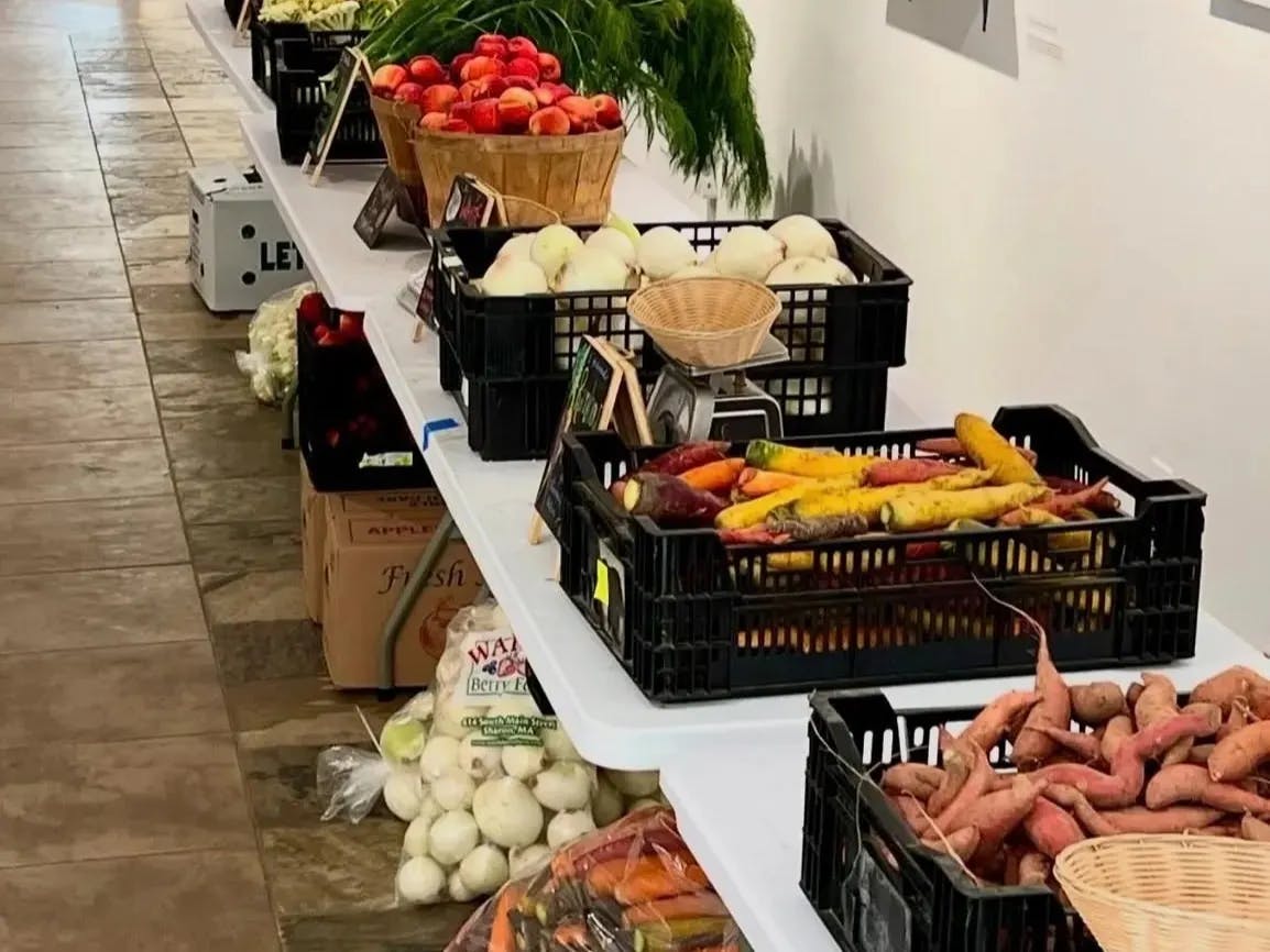 A market share photo shows potatoes, apples and carrots atop a table in Hillel.

