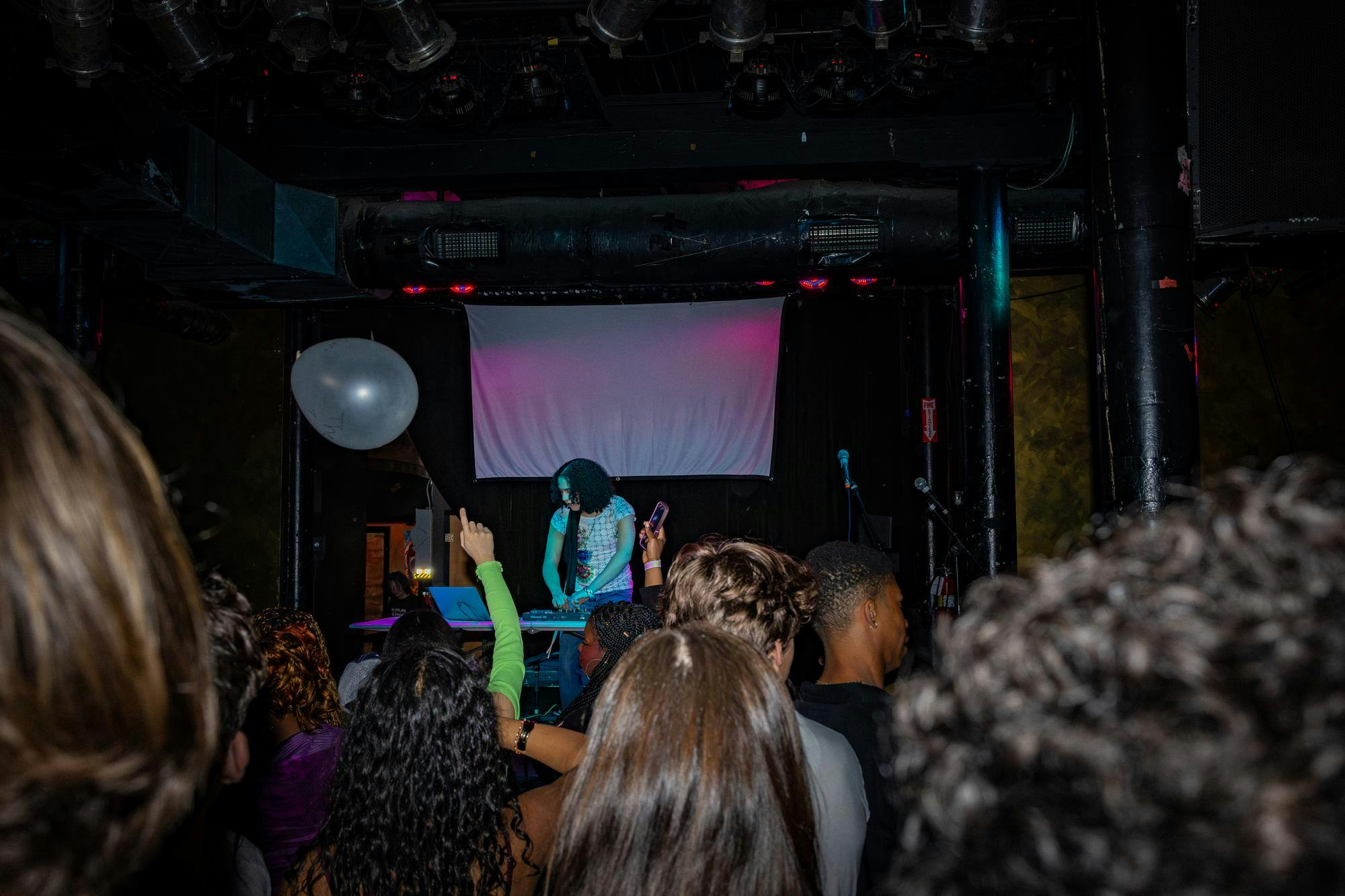 A DJ plays a set on stage in front of a crowd.