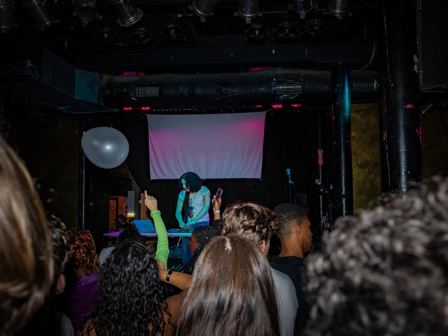 A DJ plays a set on stage in front of a crowd.