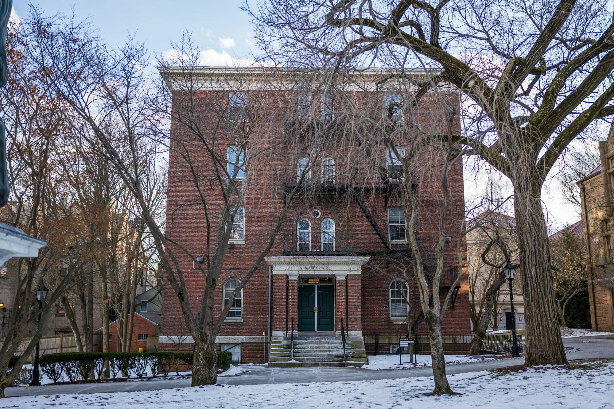 A photograph of Maxcy Hall, with bare trees in front and snow on the ground.