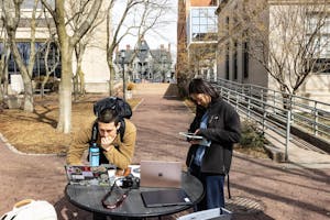 A photo depicts two students in front of the Sciences Library filling out the Herald’s 2026 Spring Poll.

