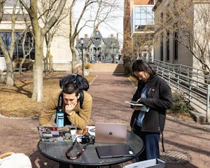 A photo depicts two students in front of the Sciences Library filling out the Herald’s 2026 Spring Poll.