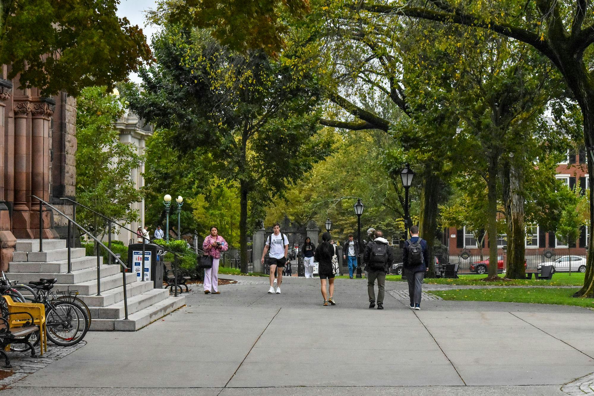 Photo of the Main Green during a high-traffic period, with many students walking and talking along the main walking path of the green.