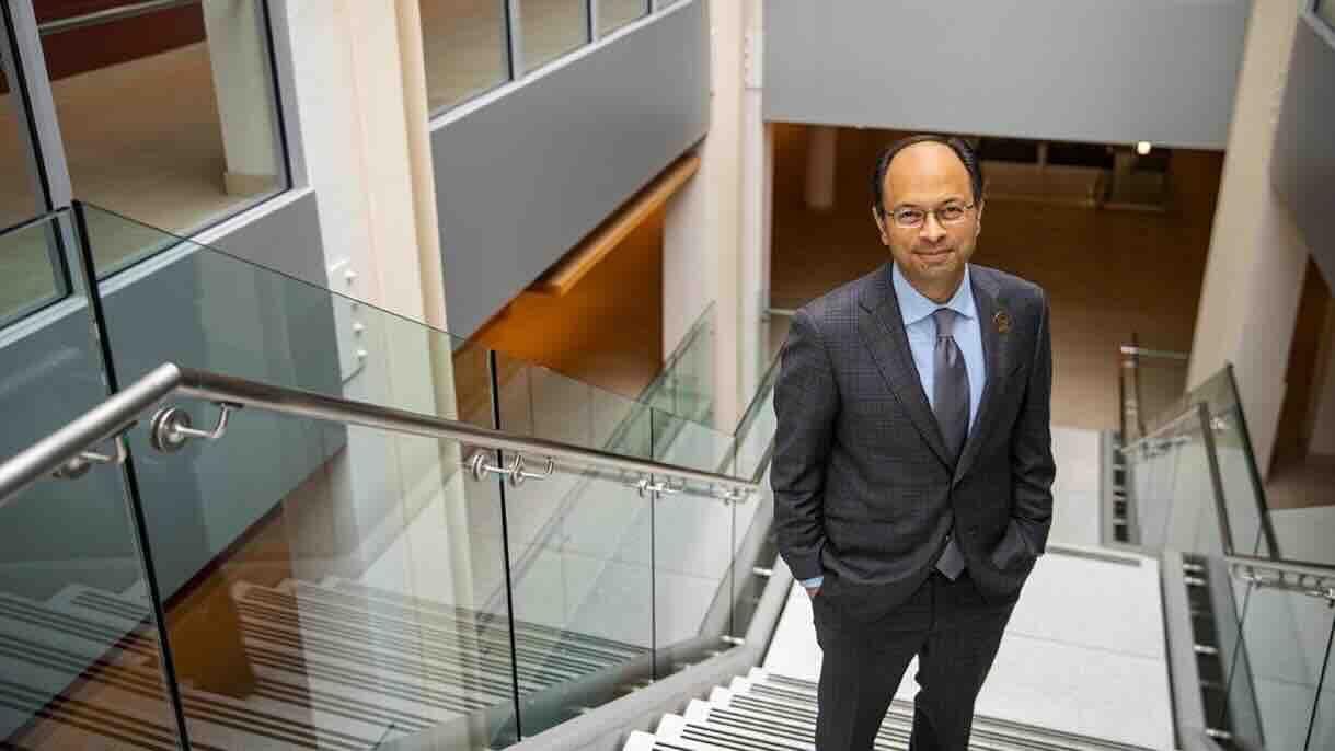 Photo of Mukesh Jain standing at the top of a stairwell. 