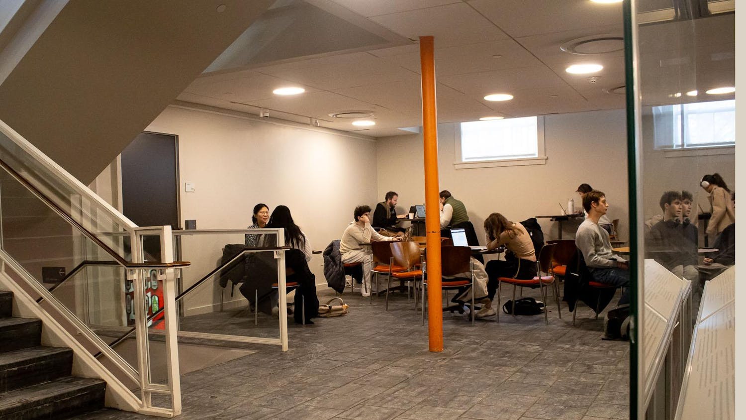 Photo of the bottom floor of the Campus Center with multiple groups of people sitting beside the tables.
