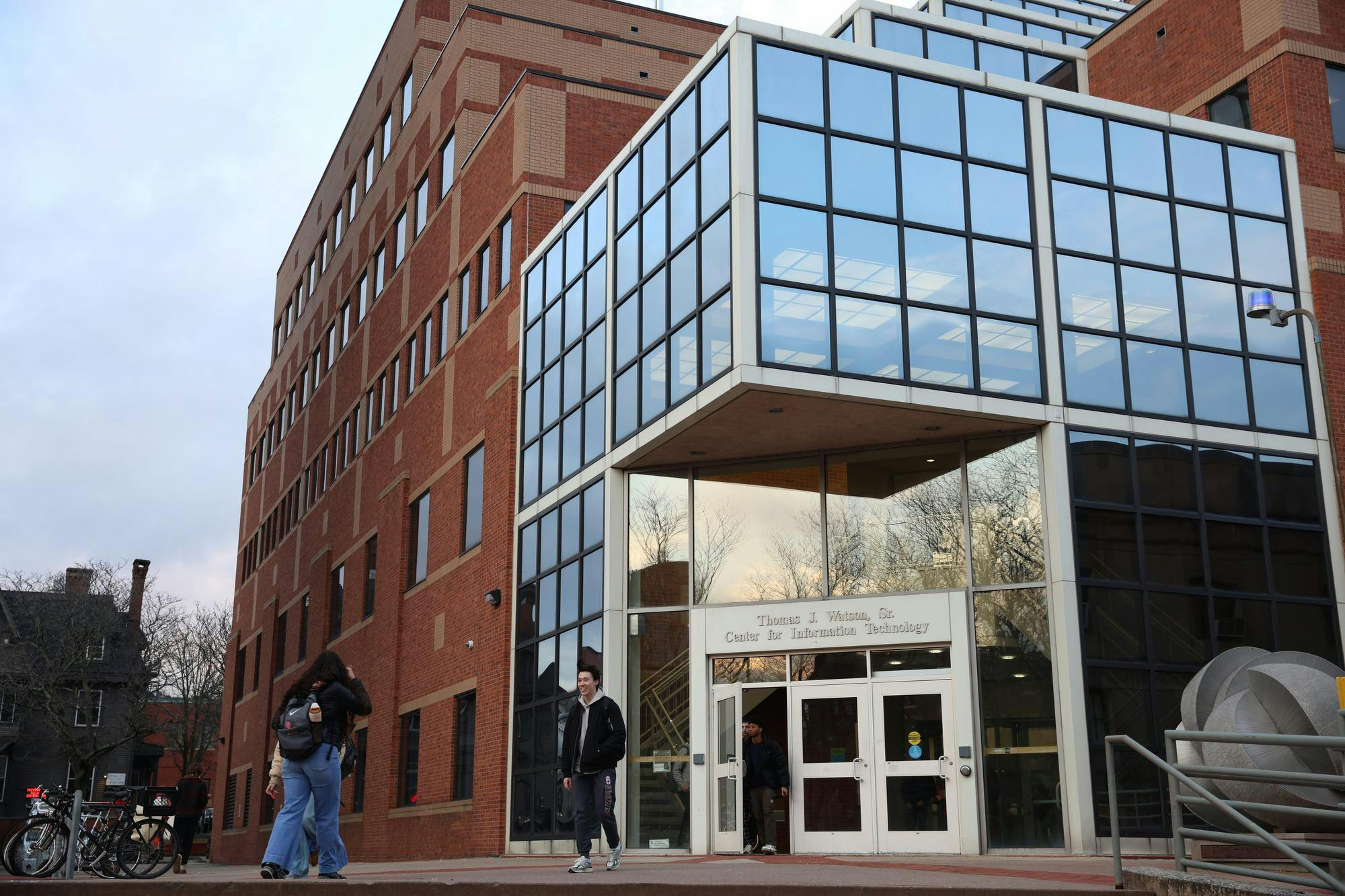 Students walk in and out of the Center for Information Technology on a sunny evening. 