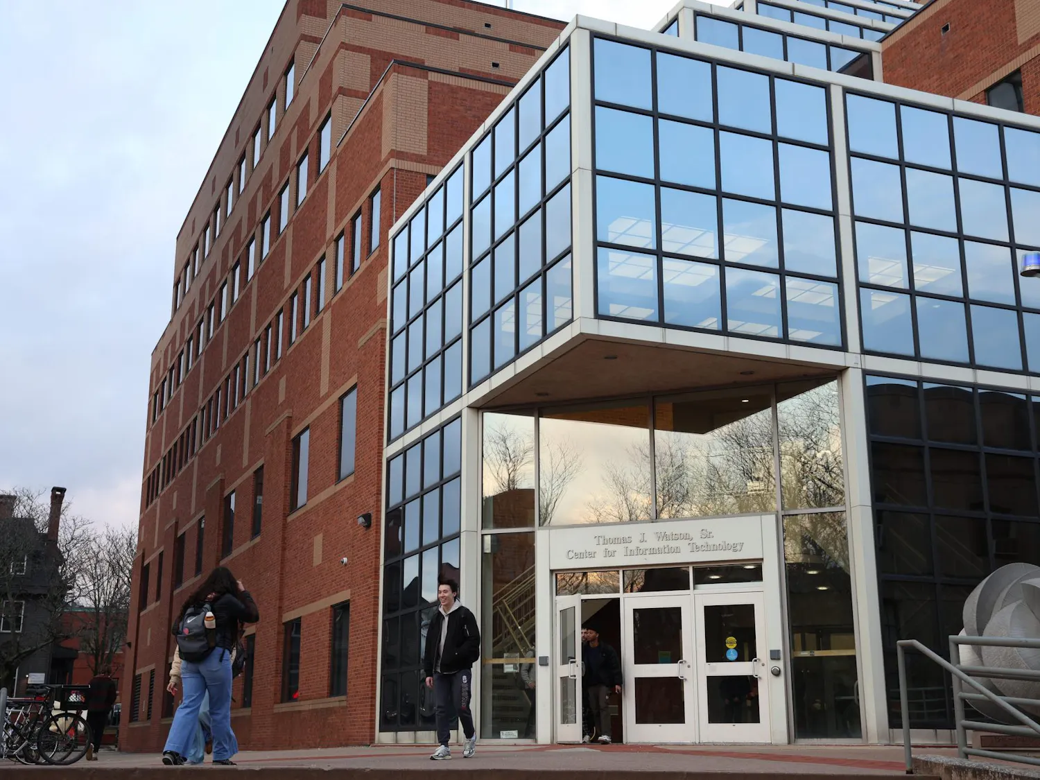 Students walk in and out of the Center for Information Technology on a sunny evening.