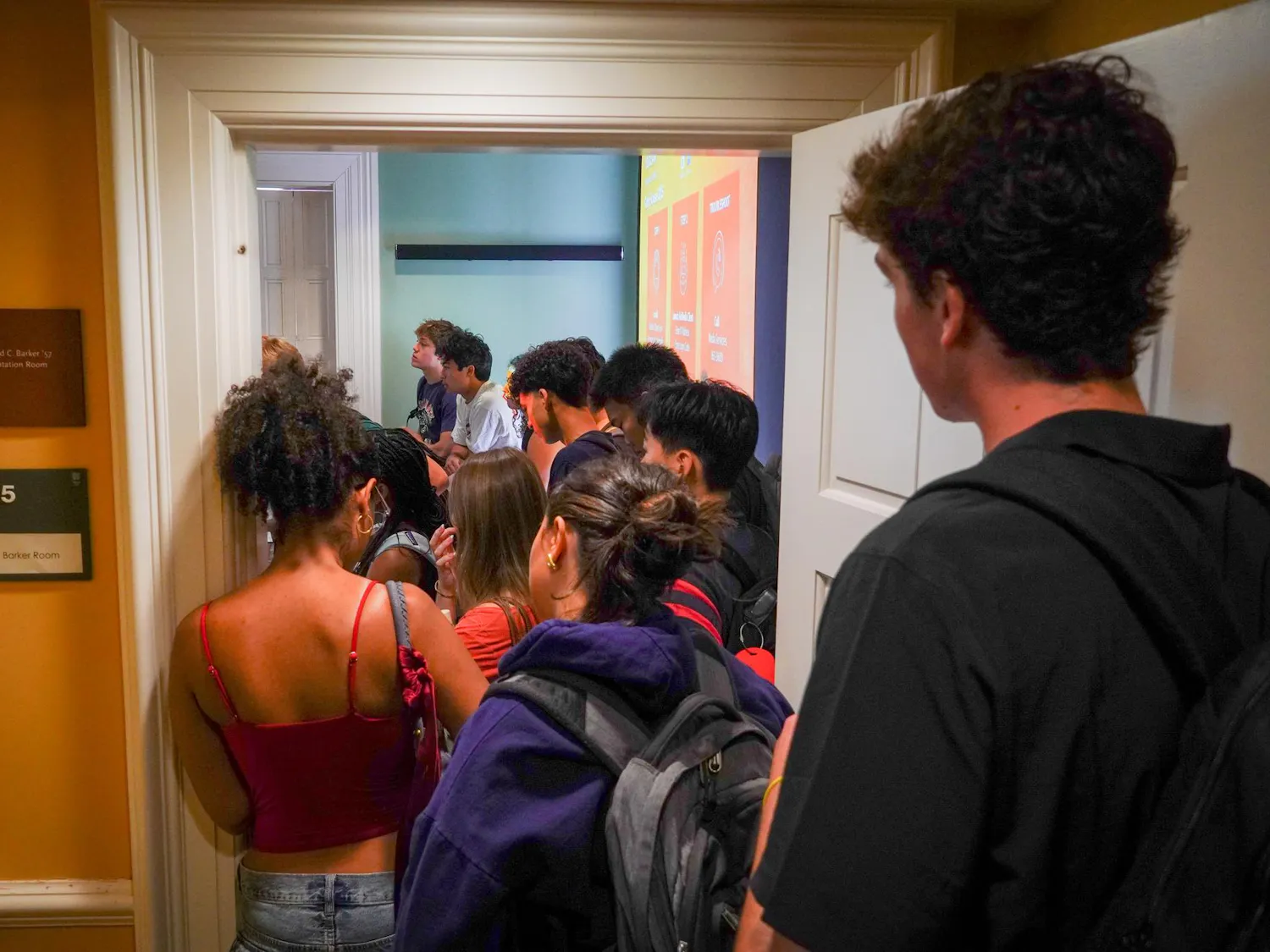A line of students spill out a doorway.