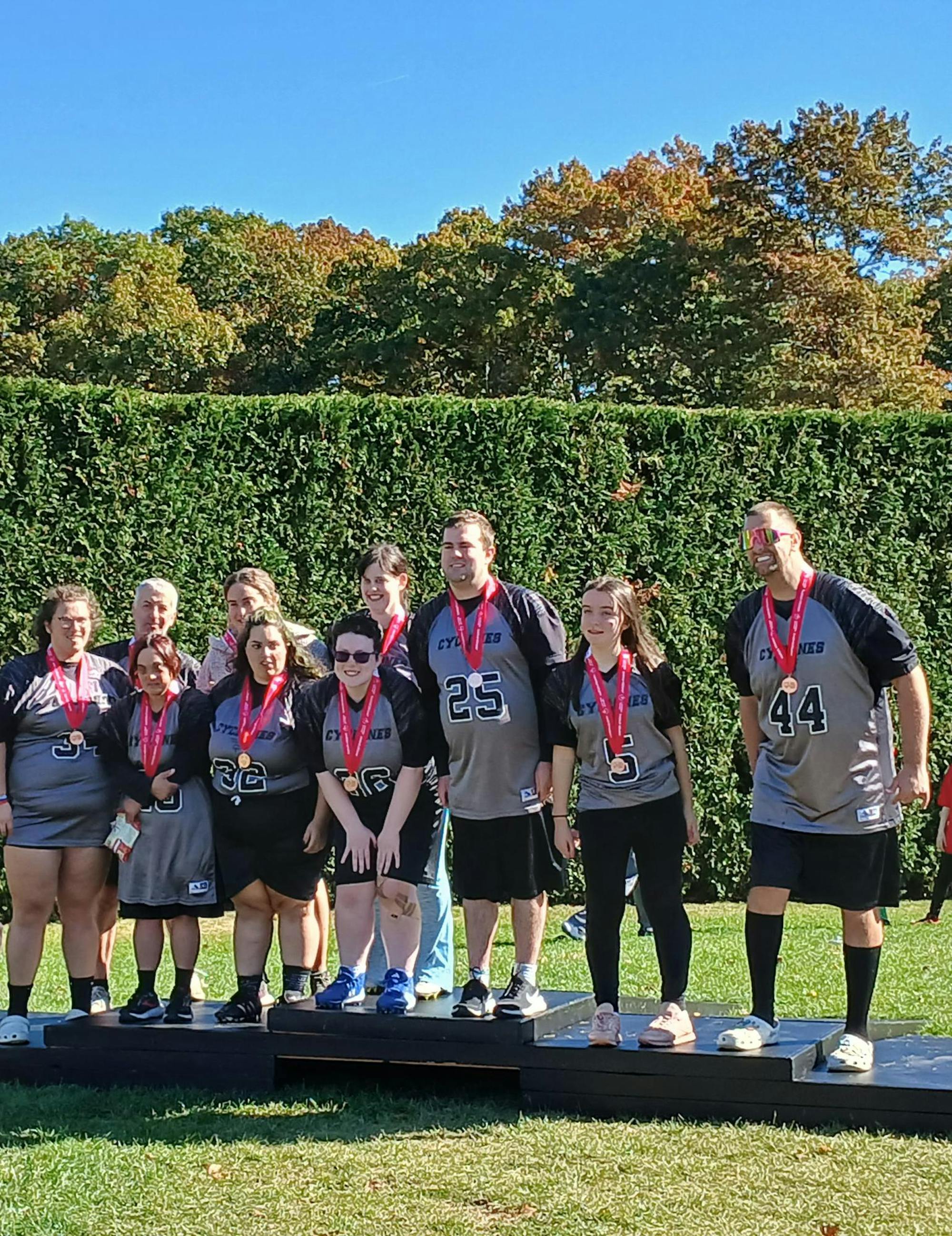 A team of players in matching jerseys stand in two rows with medals around their necks.