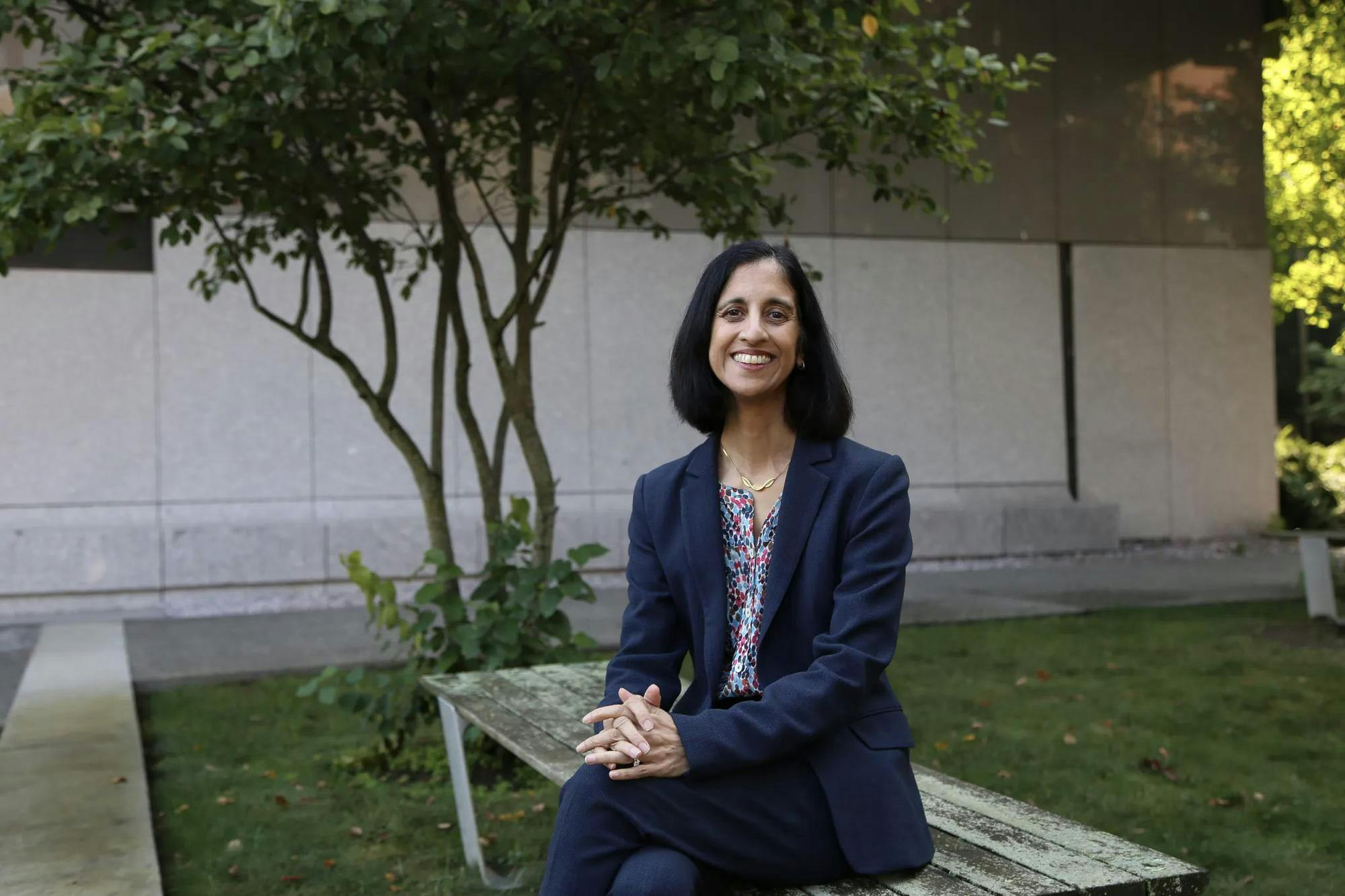 A portrait of Tejal Desai sitting on a bench.