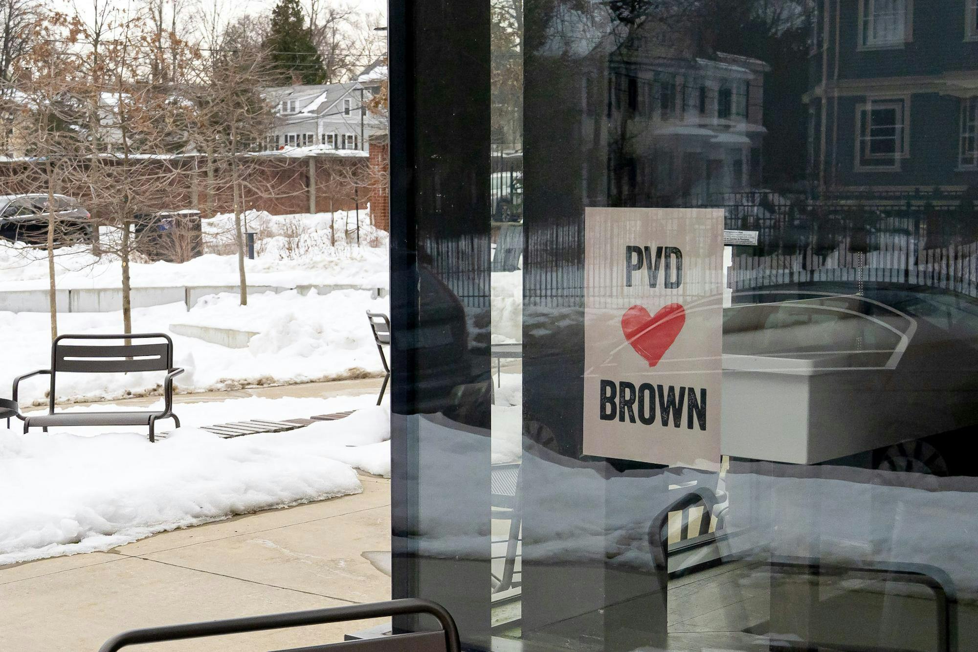 A photo of a “PVD loves Brown” flyer posted on the window of a building.