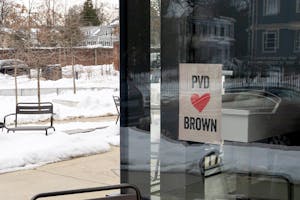 A photo of a “PVD loves Brown” flyer posted on the window of a building.