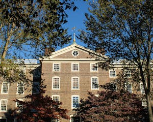 A photo of University Hall with multi-colored fall trees surrounding it.