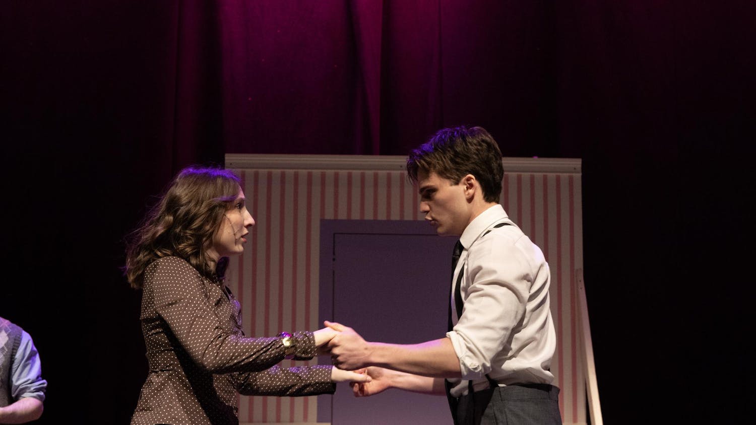A photo of Charlie Fitzgerald ’28, playing Georg Nowack, and Isabel Levine ’28, playing Amalia Balash, looking at each other and holding hands.