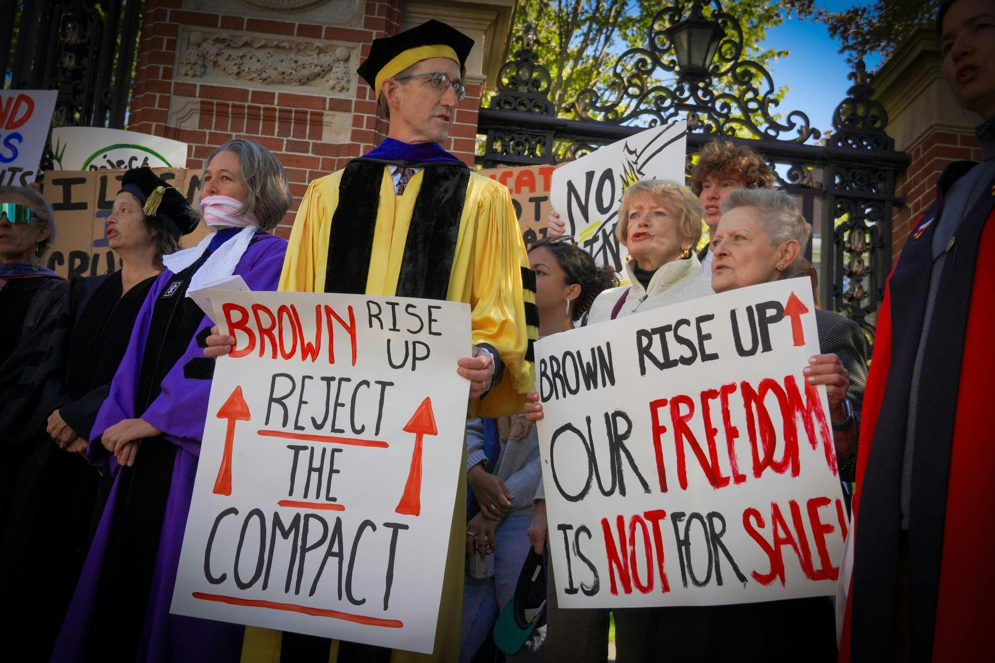 Photo of professors at protest holding signs.