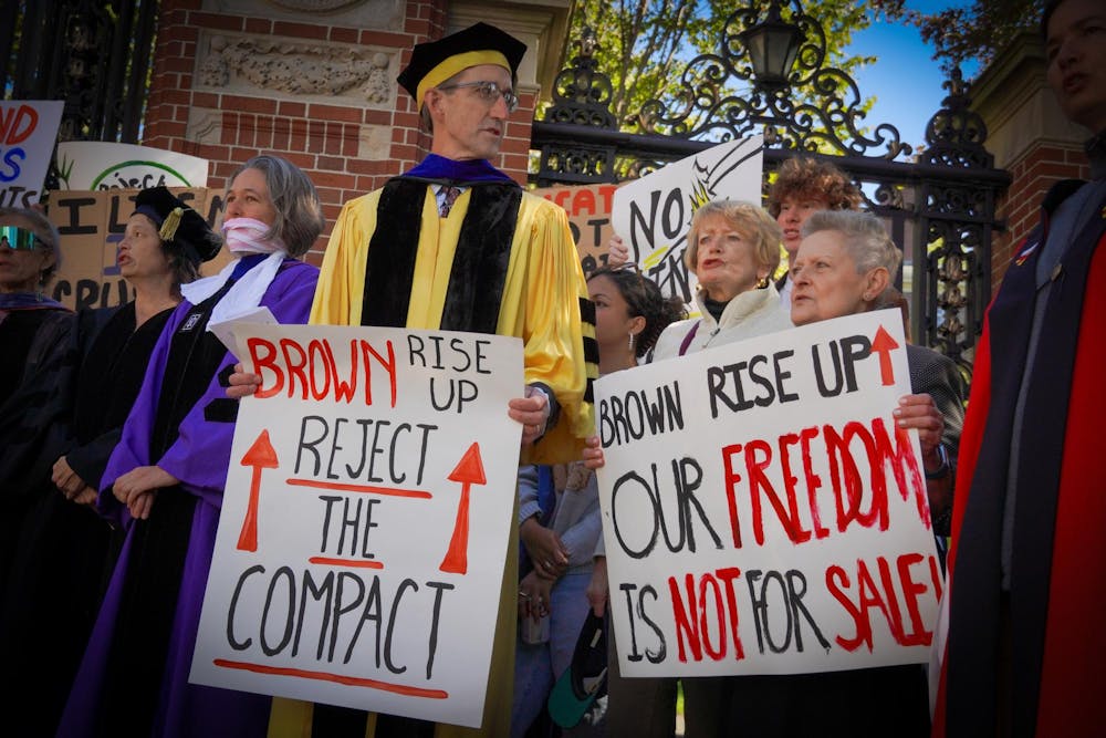 Photo of professors at protest holding signs.