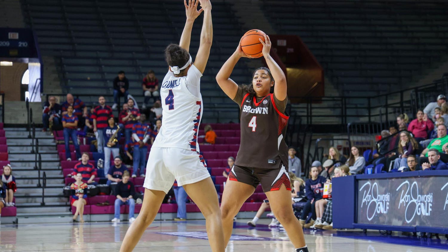 Isabella Wesely holds a basketball over her head as she is guarded by another player.
