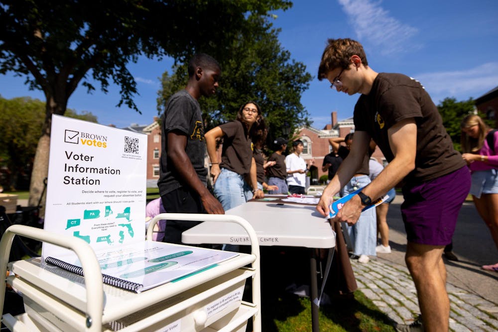 Photo of students from Brown Votes helping people register to vote, request absentee ballots and answer general questions about civic engagement on National Voter Registration Day.