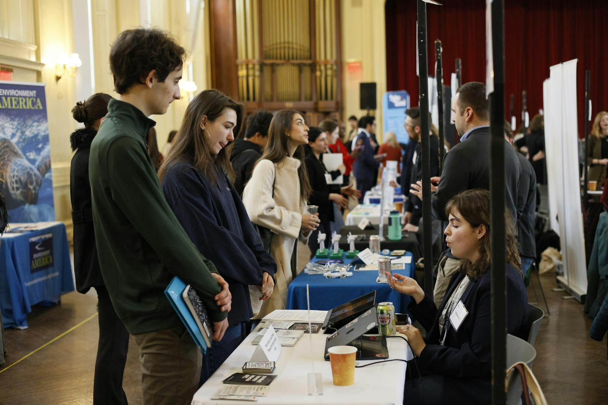 Photo of students at the Climate Career Fair talking to individuals at various booths.