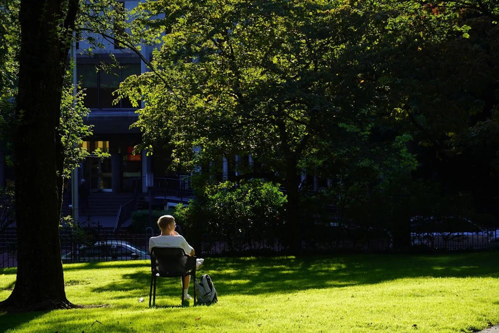 A man sits on the Main Green.