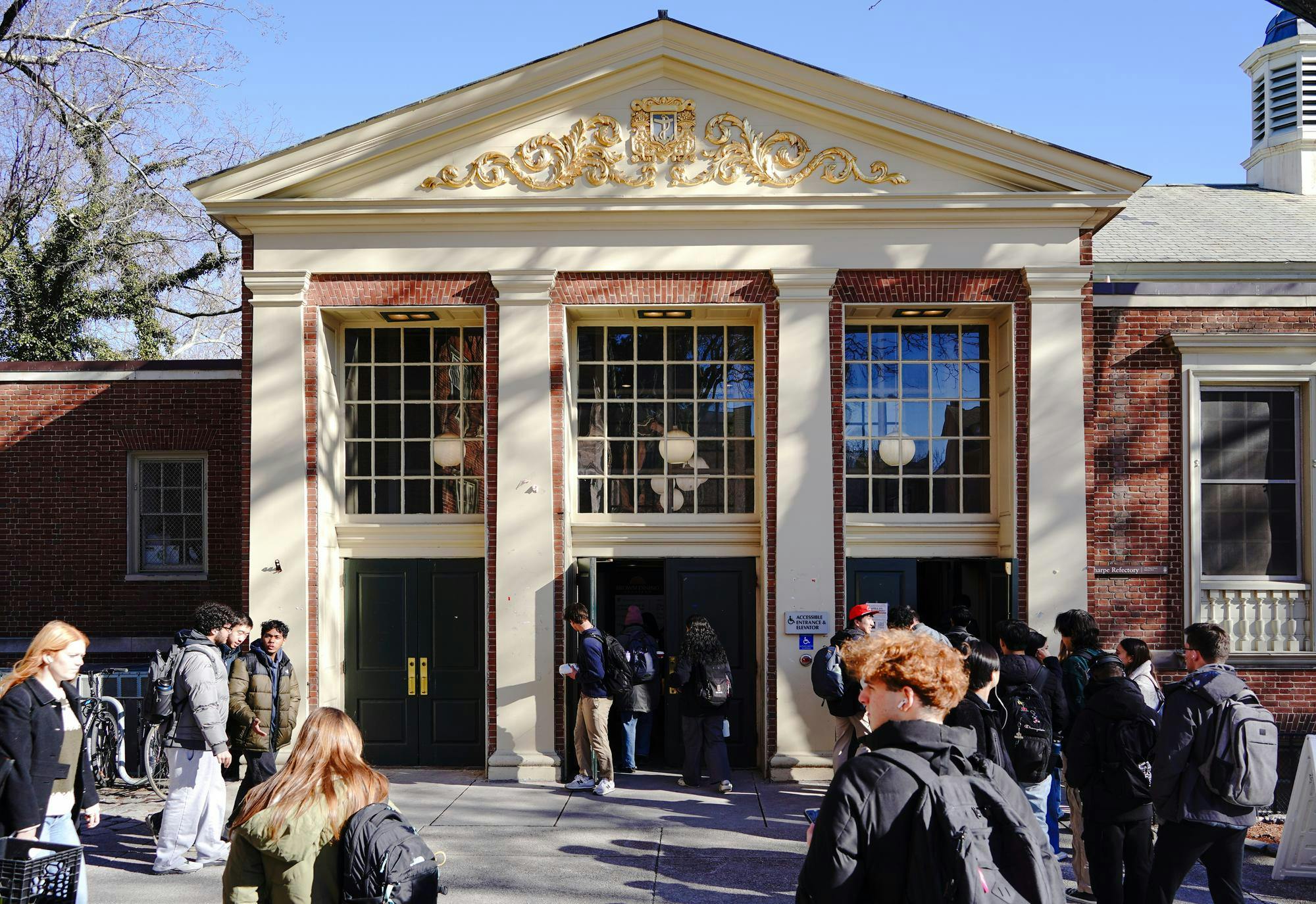 A photo of the Sharpe Refectory with students walking in and out.