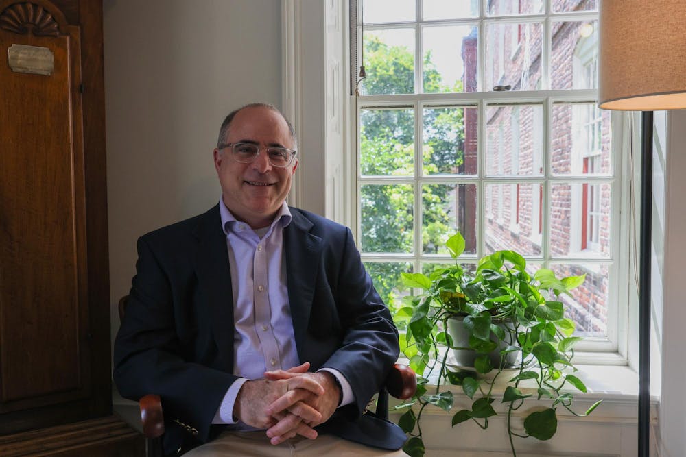 Portrait of a smiling Ethan Pollock, newly appointed dean of the College, in his office.