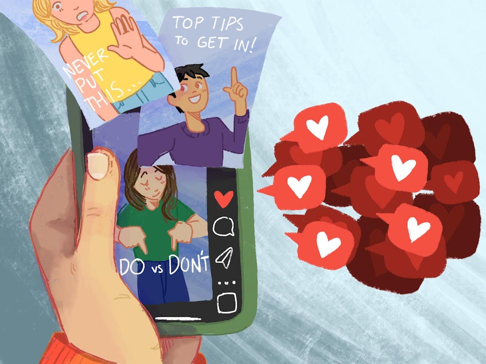 An illustration of a hand holding a phone showing videos of influencers giving advice for college admissions receiving many likes. 