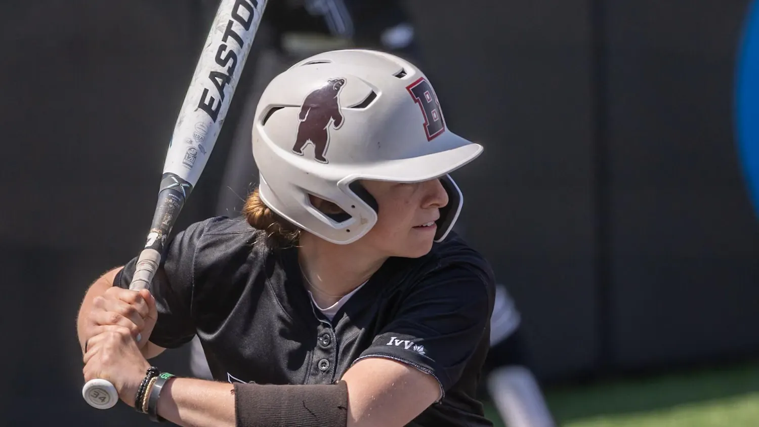 Maggie Foxx ’28 with a softball bat raised behind her head during a game.