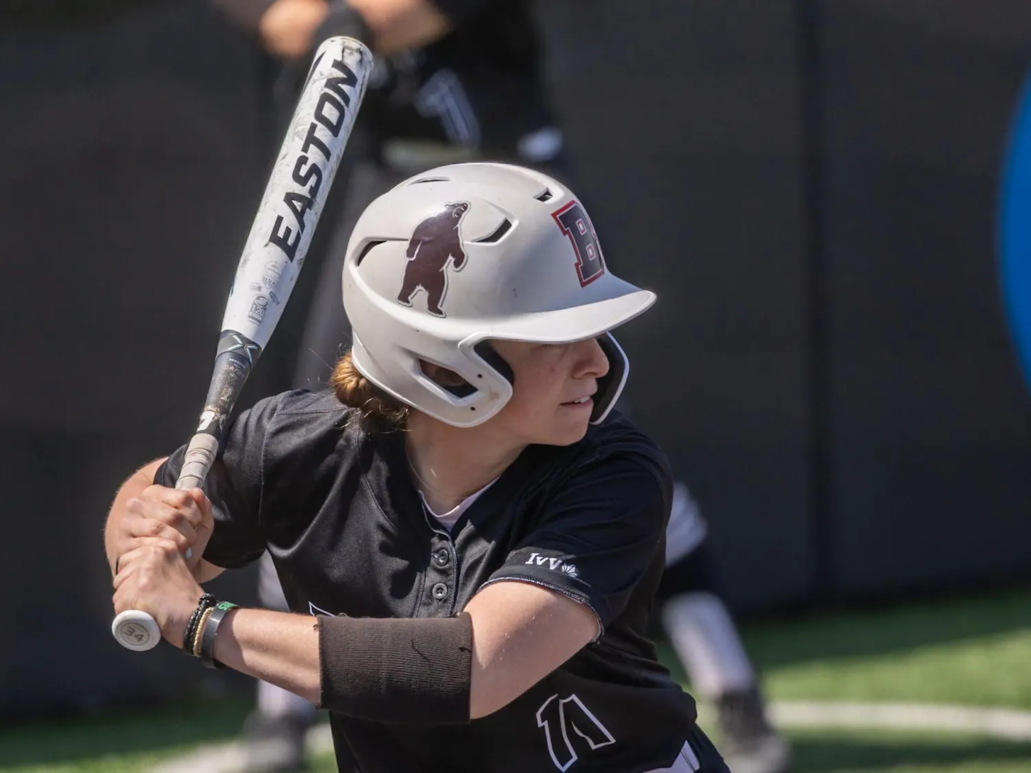 Maggie Foxx ’28 with a softball bat raised behind her head during a game.