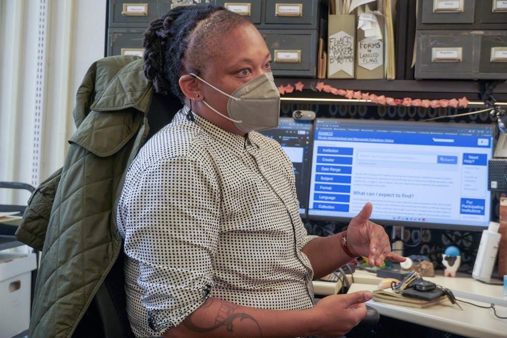 Janaya Kizzie sitting in front of her desk and talking.