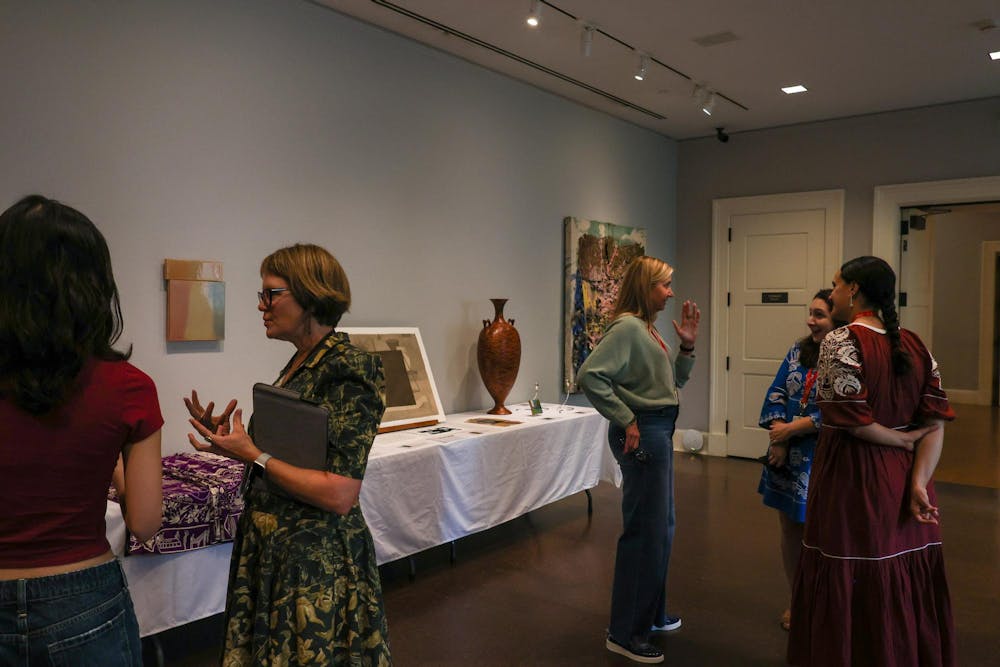 Visitors chat at the RISD Museum, surrounded by artworks of all types.