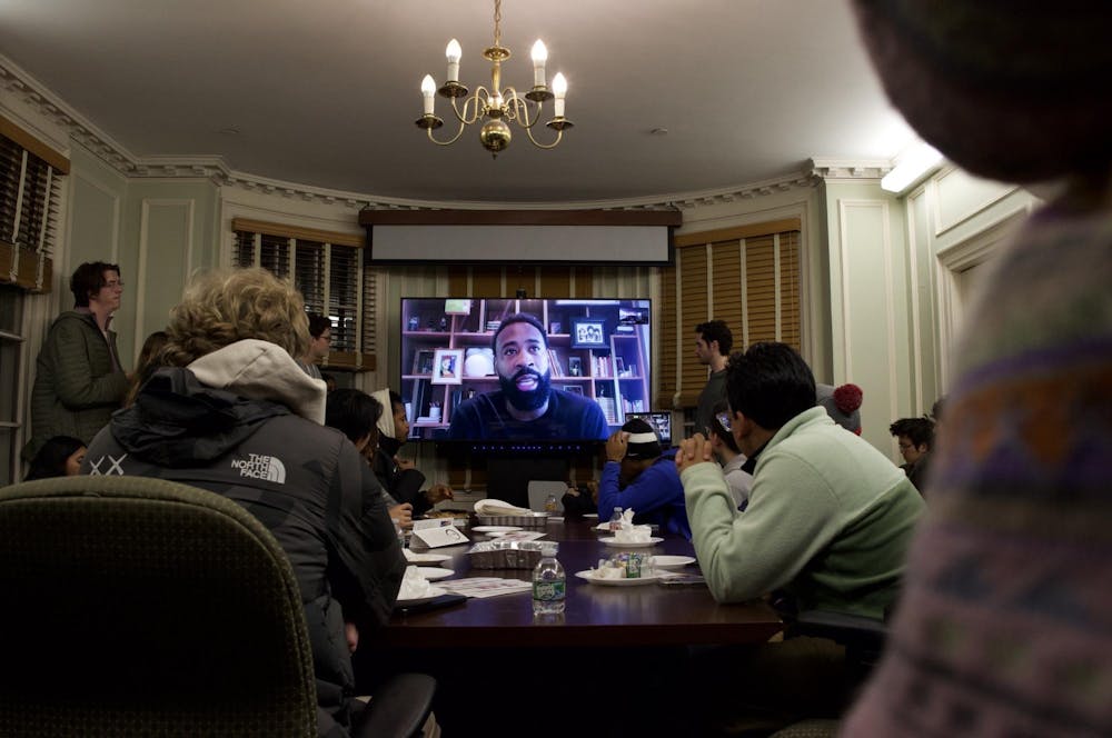 Photo during the contemplative studies event with DeAndre Jordan displayed on a TV with a full room of students listening attentively. 

