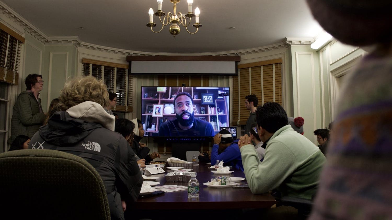 Photo during the contemplative studies event with DeAndre Jordan displayed on a TV with a full room of students listening attentively.