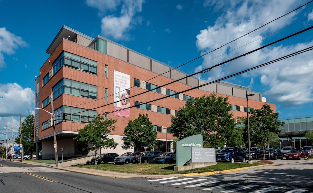 The entrance to the Women and Infants Hospital of Rhode Island. A large sign hangs down the front of the building, which features a picture of a woman and a baby and reads "Women & Infants is a Designated Baby-Friendly USA Hospital." 