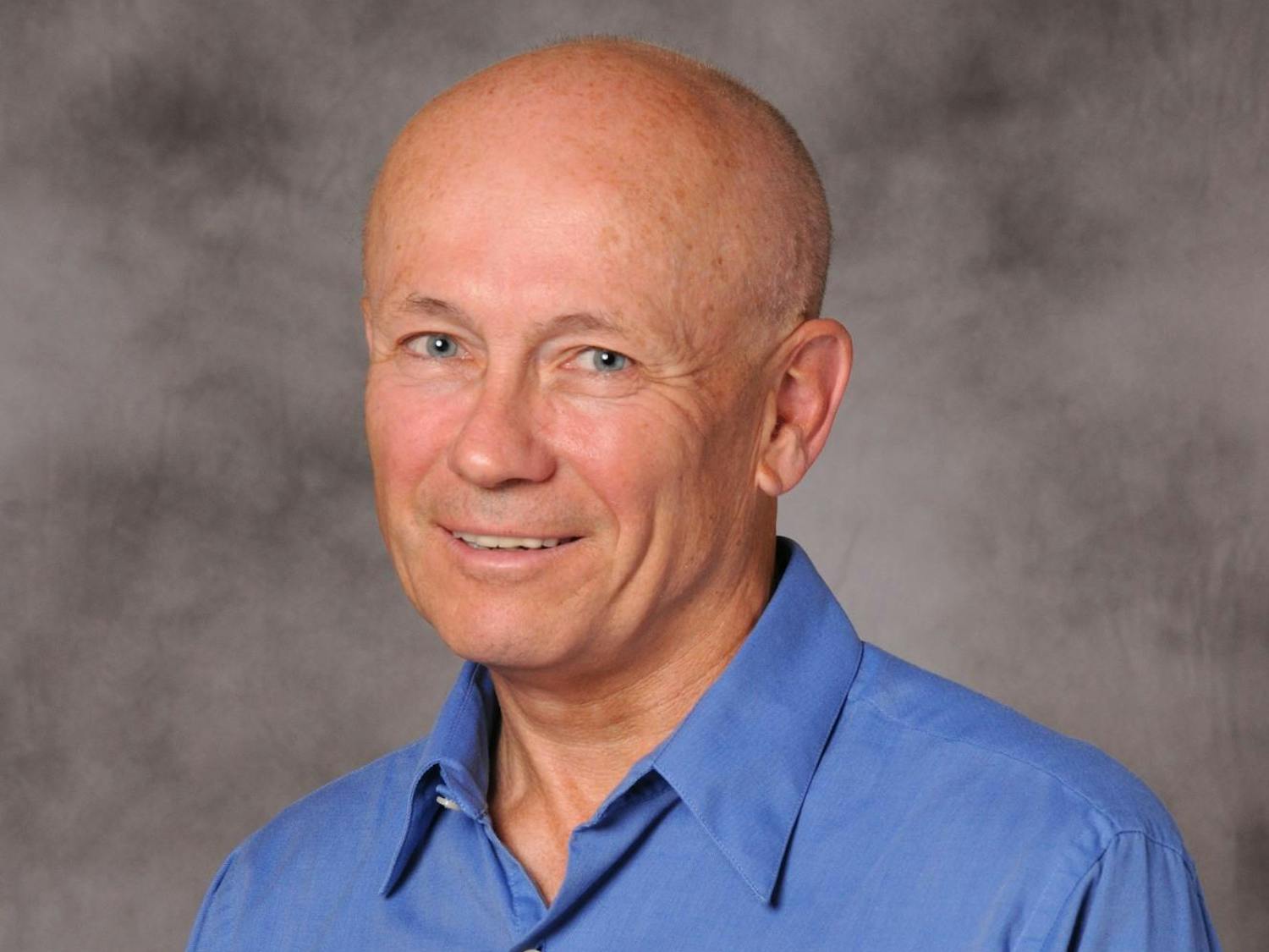 A headshot of Peter Howitt in a blue button-down shirt.