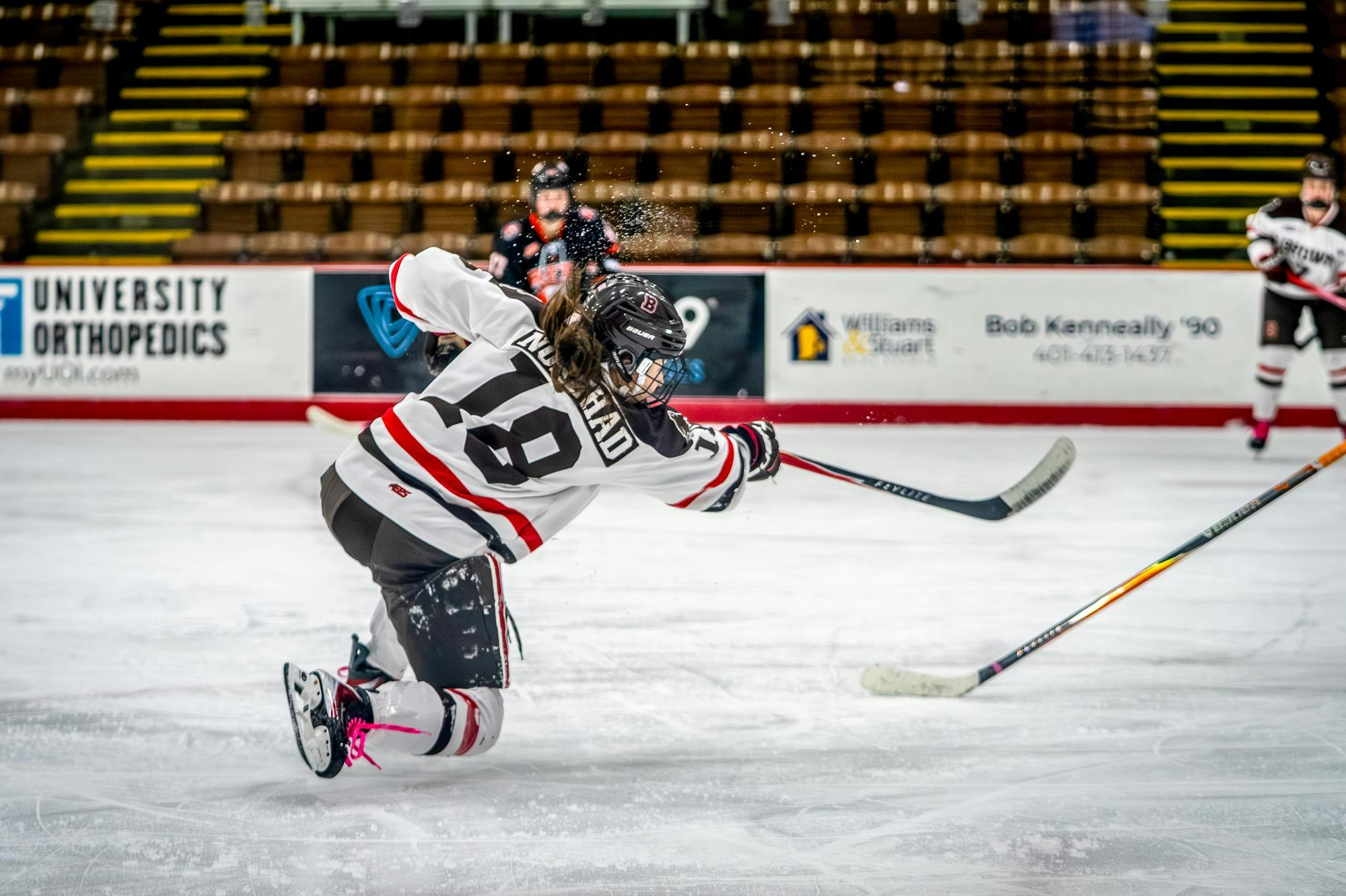 A photo of a hockey player shooting toward a goal, not visible in the picture.  