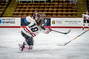 A photo of a hockey player shooting toward a goal, not visible in the picture.  