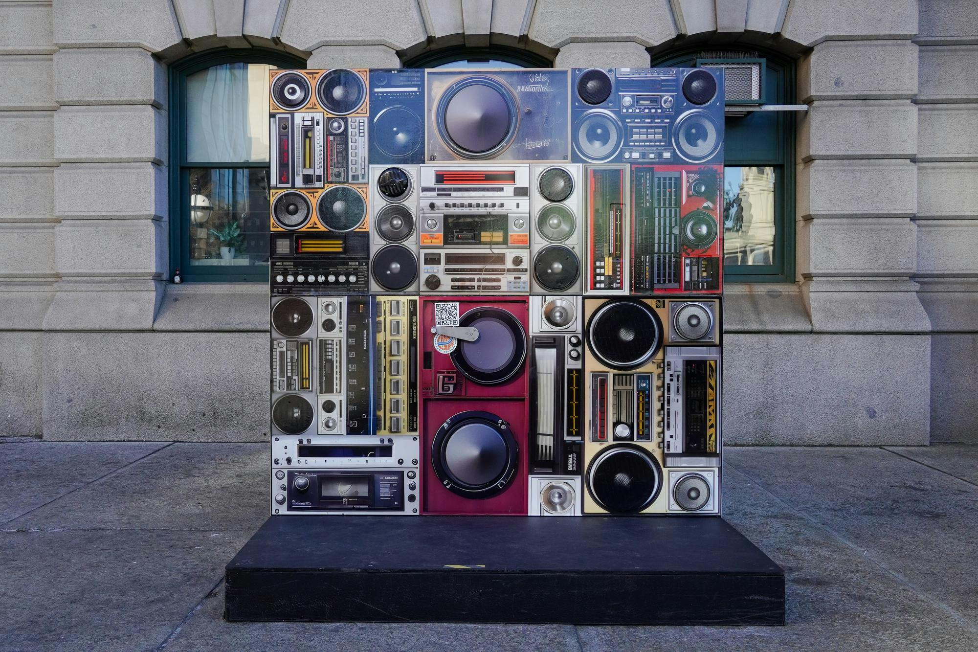 Image of a bunch of radios and speakers on a small billboard.