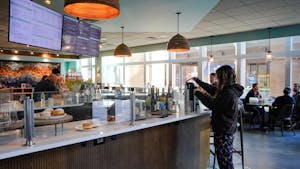 A woman getting coffee from a cafe counter.