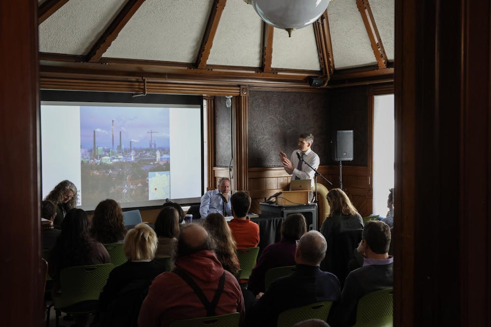 A photo of Professor Benjamin Hein presenting a slideshow to an audience in a classroom. 