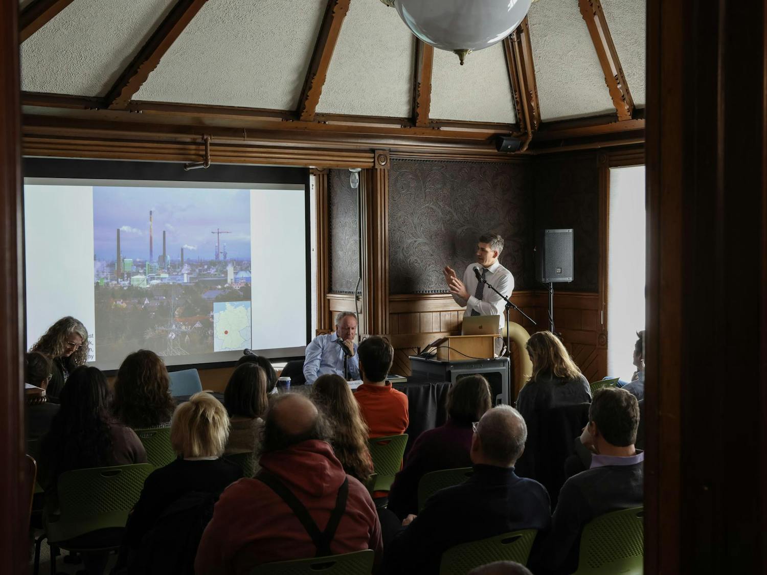 A photo of Professor Benjamin Hein presenting a slideshow to an audience in a classroom.
